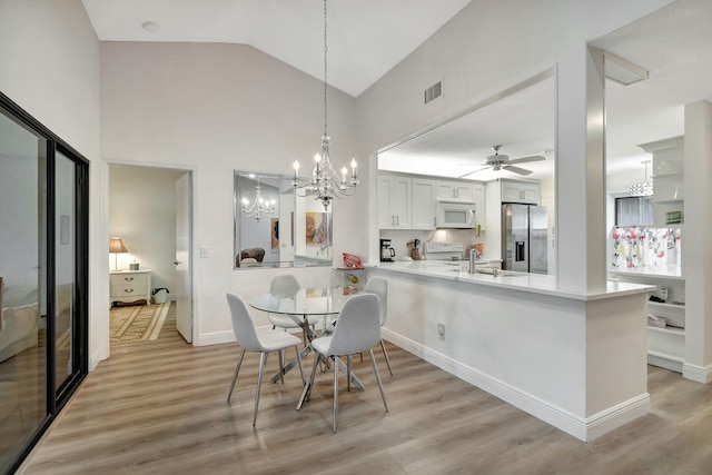 8306 Mooring Cir, Boynton Beach, FL 33472 - dining space with a chandelier, light wood-style flooring, and lofted ceiling