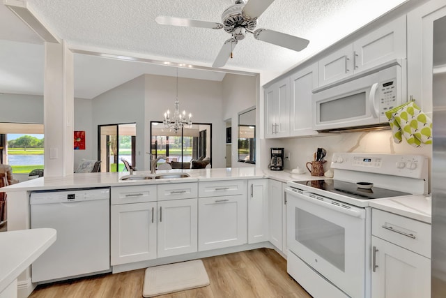 8306 Mooring Cir, Boynton Beach, FL 33472 - kitchen featuring white appliances, a sink, a peninsula, a textured ceiling, and plenty of natural light