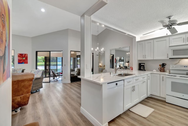 kitchen with lofted ceiling, white cabinets, kitchen peninsula, sink, and white appliances