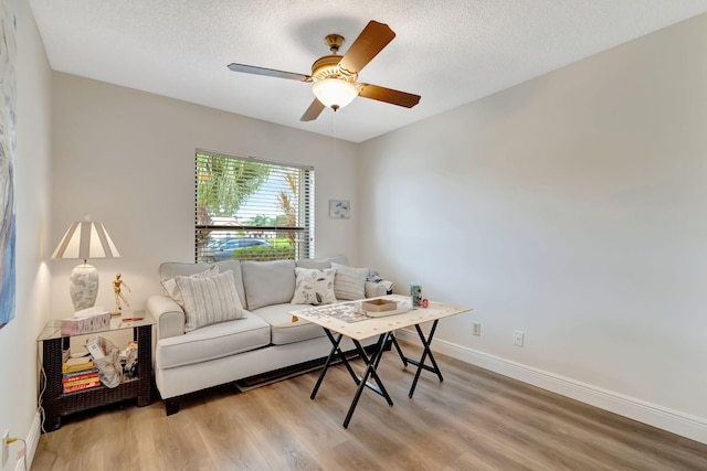 living room featuring a textured ceiling, ceiling fan, and light hardwood / wood-style flooring