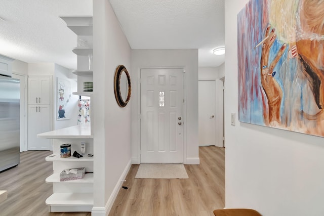 entrance foyer with a textured ceiling and light wood-type flooring