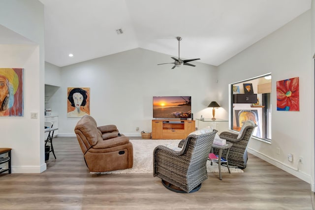 living room featuring ceiling fan, wood-type flooring, and vaulted ceiling