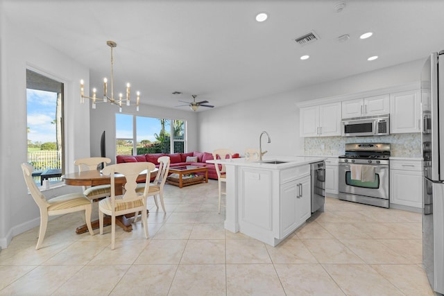 kitchen featuring decorative light fixtures, white cabinetry, sink, and appliances with stainless steel finishes