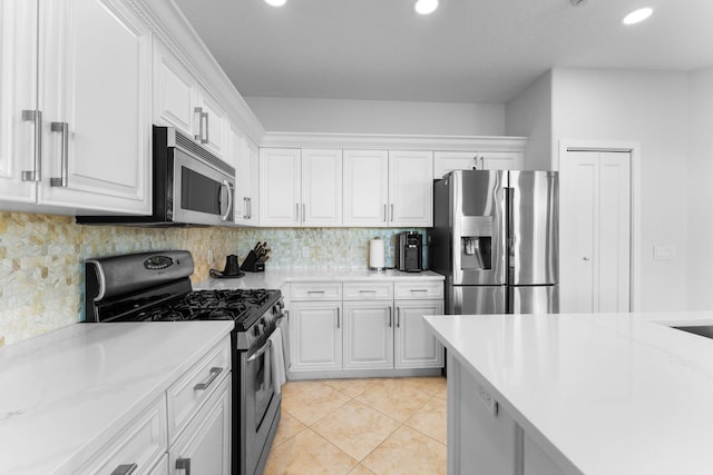 kitchen with white cabinets, decorative backsplash, light tile patterned flooring, and appliances with stainless steel finishes