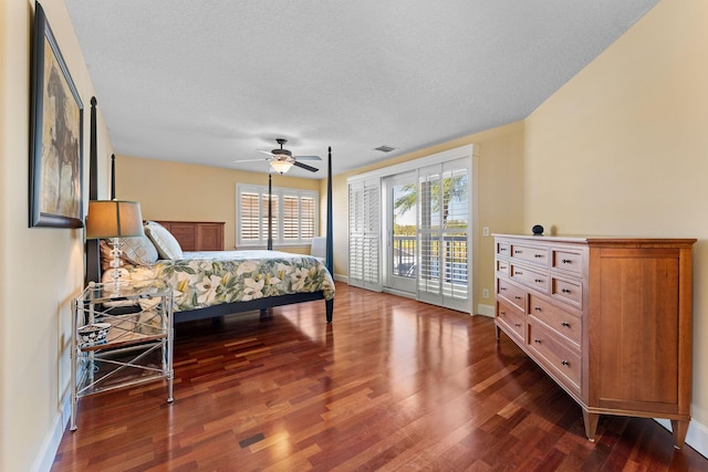 bedroom featuring a textured ceiling, access to outside, ceiling fan, and dark wood-type flooring