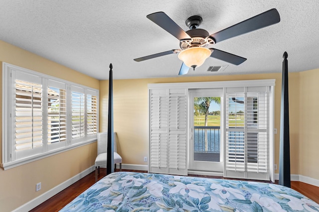 bedroom featuring ceiling fan, dark wood-type flooring, and a textured ceiling