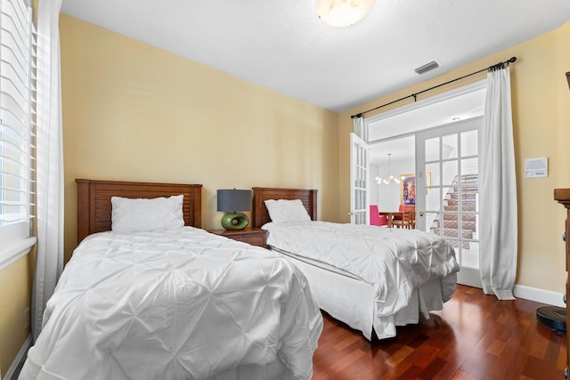 bedroom with dark hardwood / wood-style flooring and an inviting chandelier