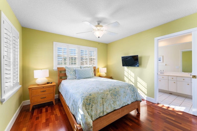 bedroom featuring a textured ceiling, hardwood / wood-style flooring, ceiling fan, and ensuite bathroom