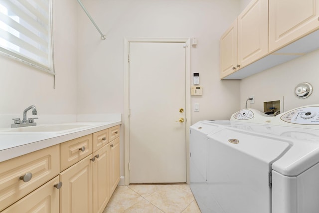 laundry area with cabinets, light tile patterned floors, washing machine and clothes dryer, and sink