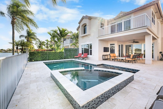 rear view of house featuring an outdoor hangout area, a pool with hot tub, ceiling fan, a balcony, and a patio area