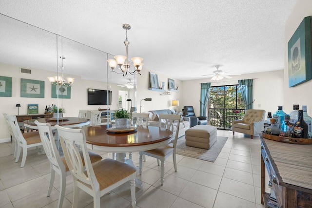 tiled dining room with ceiling fan with notable chandelier and a textured ceiling