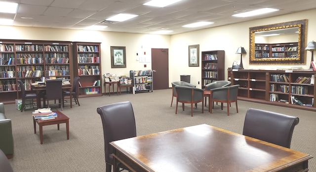 home office with a paneled ceiling and carpet