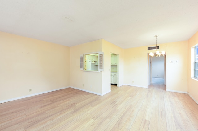 unfurnished dining area with a notable chandelier and light hardwood / wood-style floors