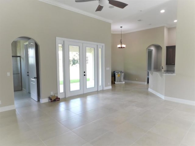 interior space with ceiling fan, french doors, light tile patterned floors, and ornamental molding