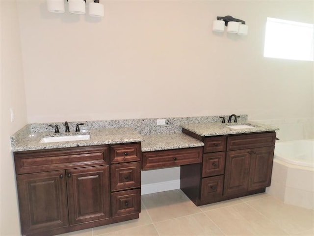 bathroom featuring tile patterned floors, tiled tub, and vanity