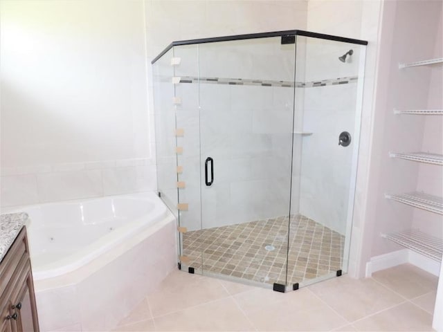 bathroom featuring tile patterned floors, vanity, and shower with separate bathtub