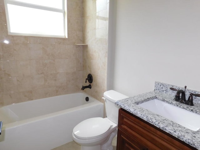 full bathroom with tiled shower / bath, vanity, and toilet