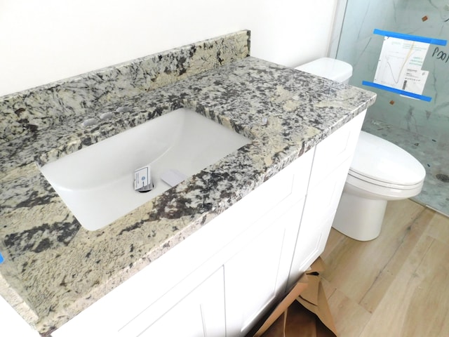 bathroom featuring hardwood / wood-style floors, vanity, and toilet