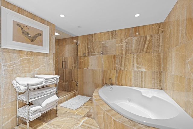 bathroom featuring tile walls and shower with separate bathtub