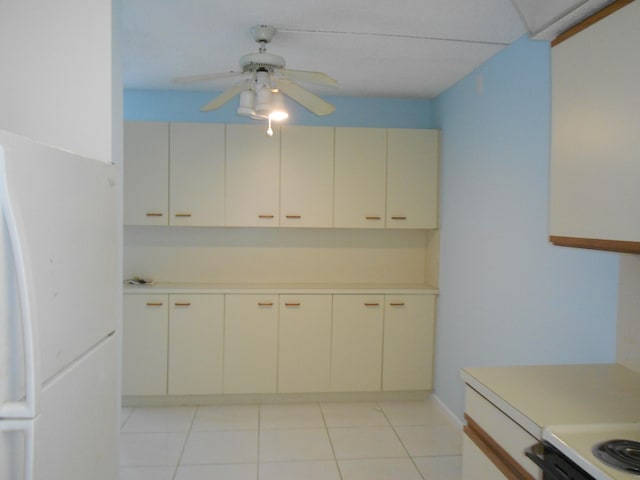 kitchen with light tile patterned flooring, ceiling fan, and white fridge