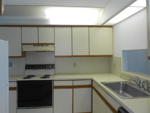 kitchen featuring white appliances, sink, and white cabinets