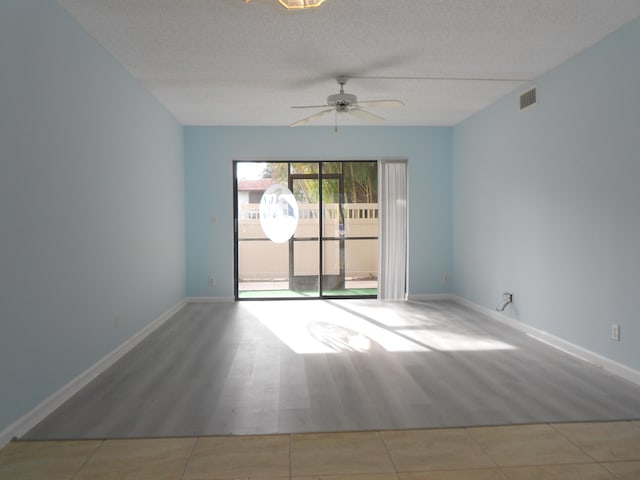 tiled spare room featuring a textured ceiling and ceiling fan