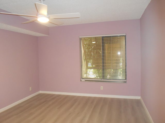 spare room featuring hardwood / wood-style floors and ceiling fan