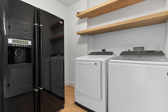 laundry room featuring light hardwood / wood-style flooring and washing machine and clothes dryer