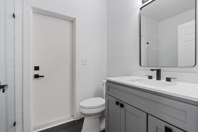 bathroom with an enclosed shower, vanity, tile patterned floors, and toilet