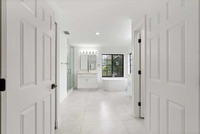 bathroom with tile patterned flooring, vanity, and separate shower and tub