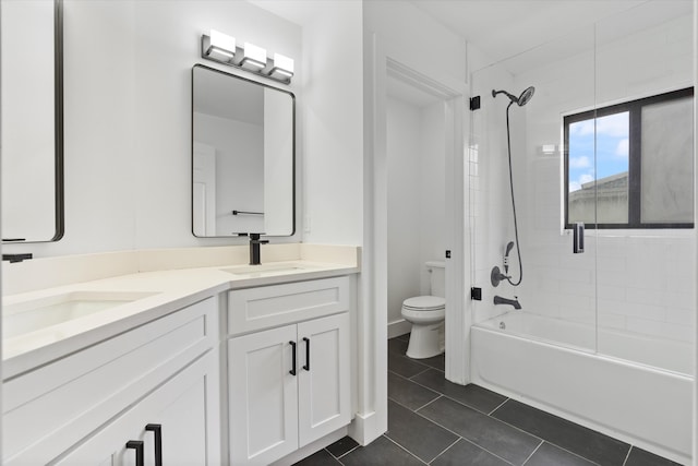 full bathroom with tile patterned flooring, tiled shower / bath, toilet, and vanity