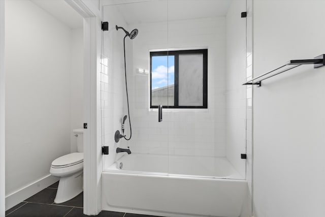 bathroom with tiled shower / bath, tile patterned floors, and toilet