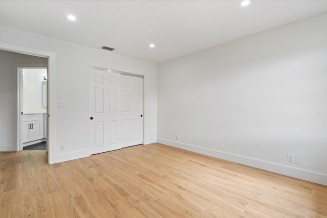 unfurnished bedroom featuring light hardwood / wood-style flooring and a closet