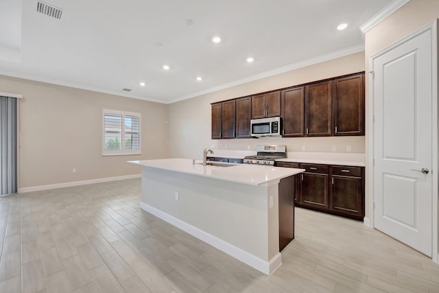 kitchen with a center island with sink, stainless steel appliances, sink, and light hardwood / wood-style flooring