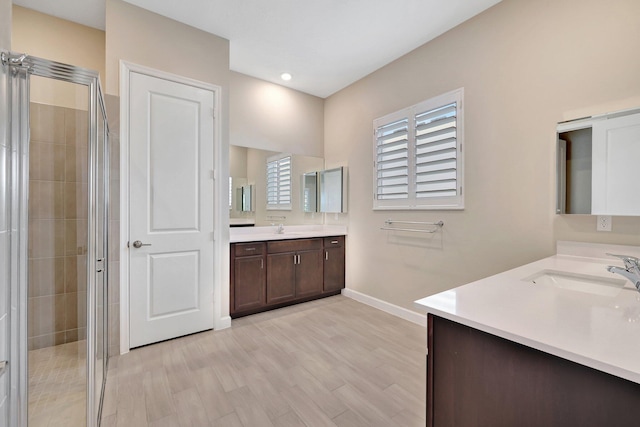 bathroom with walk in shower, vanity, and hardwood / wood-style flooring