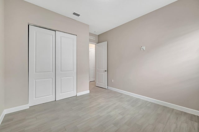 unfurnished bedroom featuring light hardwood / wood-style floors and a closet