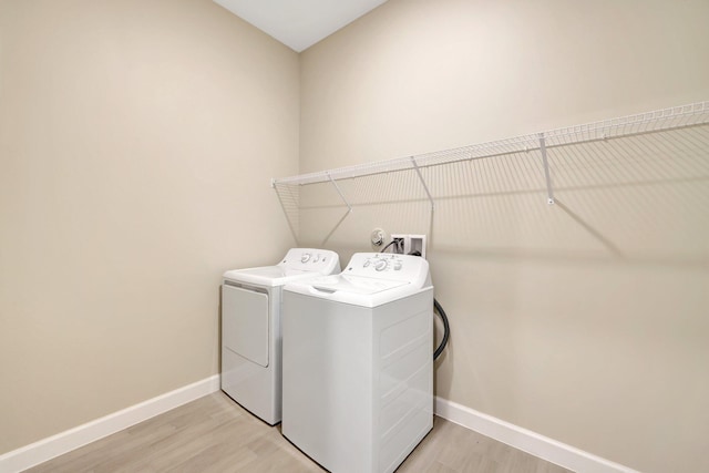 washroom featuring light hardwood / wood-style floors and washer and dryer