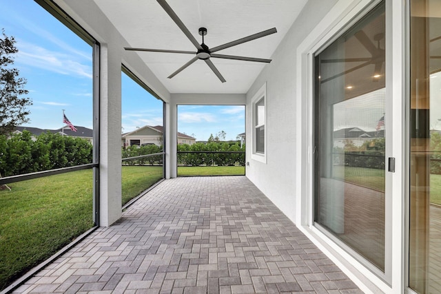 unfurnished sunroom with ceiling fan