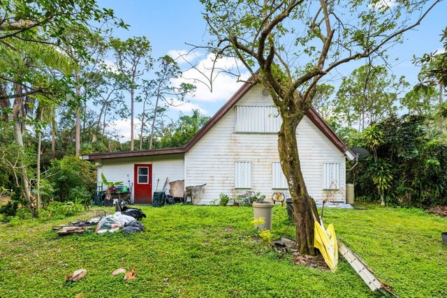 rear view of property featuring a lawn