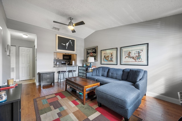 living room with a textured ceiling, ceiling fan, hardwood / wood-style floors, and lofted ceiling