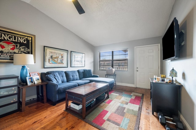 living room with a textured ceiling, ceiling fan, dark hardwood / wood-style flooring, and lofted ceiling