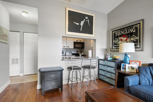 living room featuring wood-type flooring and a textured ceiling