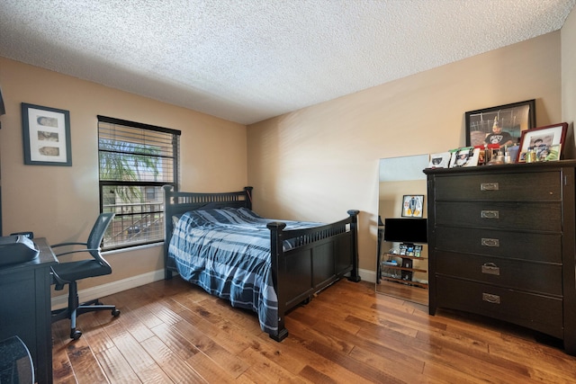 bedroom with dark hardwood / wood-style flooring and a textured ceiling