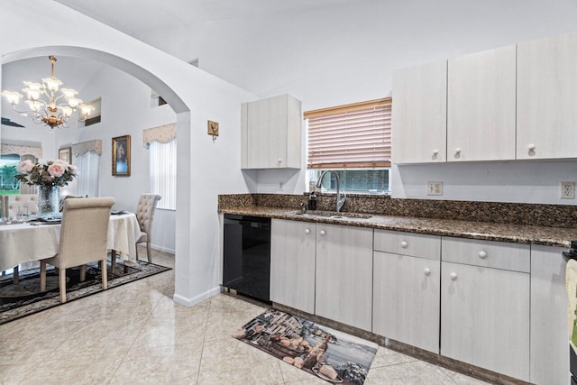 kitchen featuring dark stone counters, black dishwasher, pendant lighting, sink, and lofted ceiling