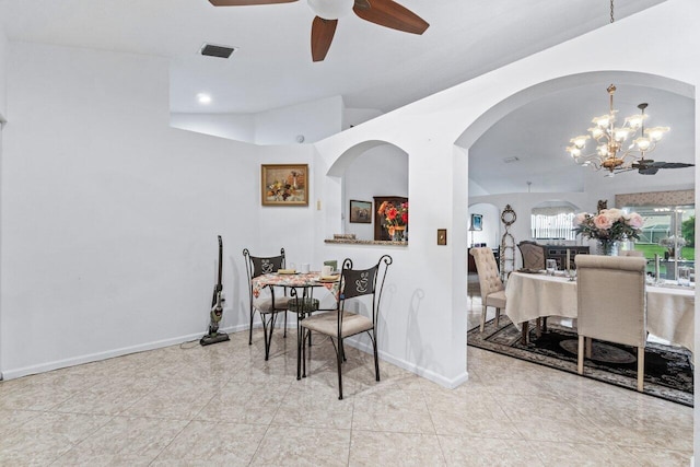 tiled dining room with ceiling fan with notable chandelier and vaulted ceiling