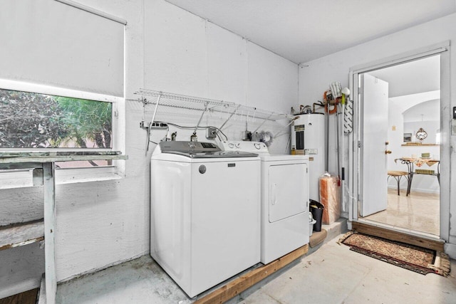 laundry area with electric water heater and separate washer and dryer