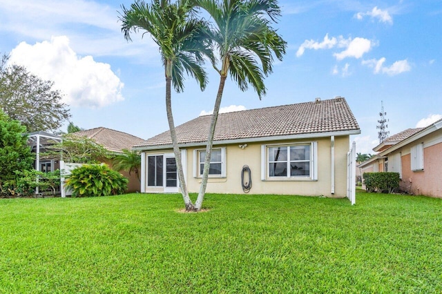 rear view of property with a yard