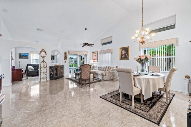 dining room featuring ceiling fan with notable chandelier and high vaulted ceiling