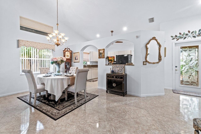 dining space featuring a chandelier, a wealth of natural light, and lofted ceiling