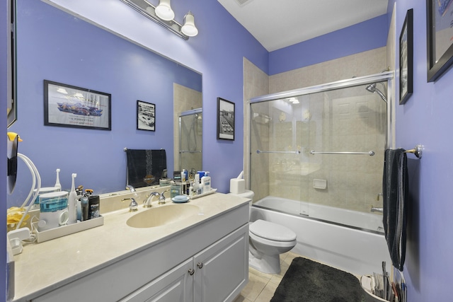 full bathroom featuring toilet, vanity, tile patterned floors, and shower / bath combination with glass door